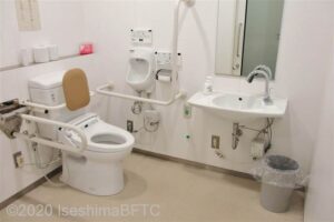 2階車いす対応トイレ内部　入口から見て左奥に、よこ置きに便器がある。入口正面に洗面台