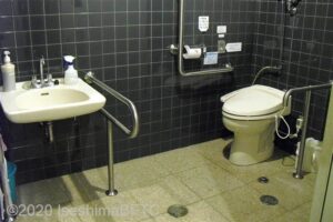 真珠博物館内1階トイレ　入口からみて右奥に、よこ置きに便器。入口正面に洗面台