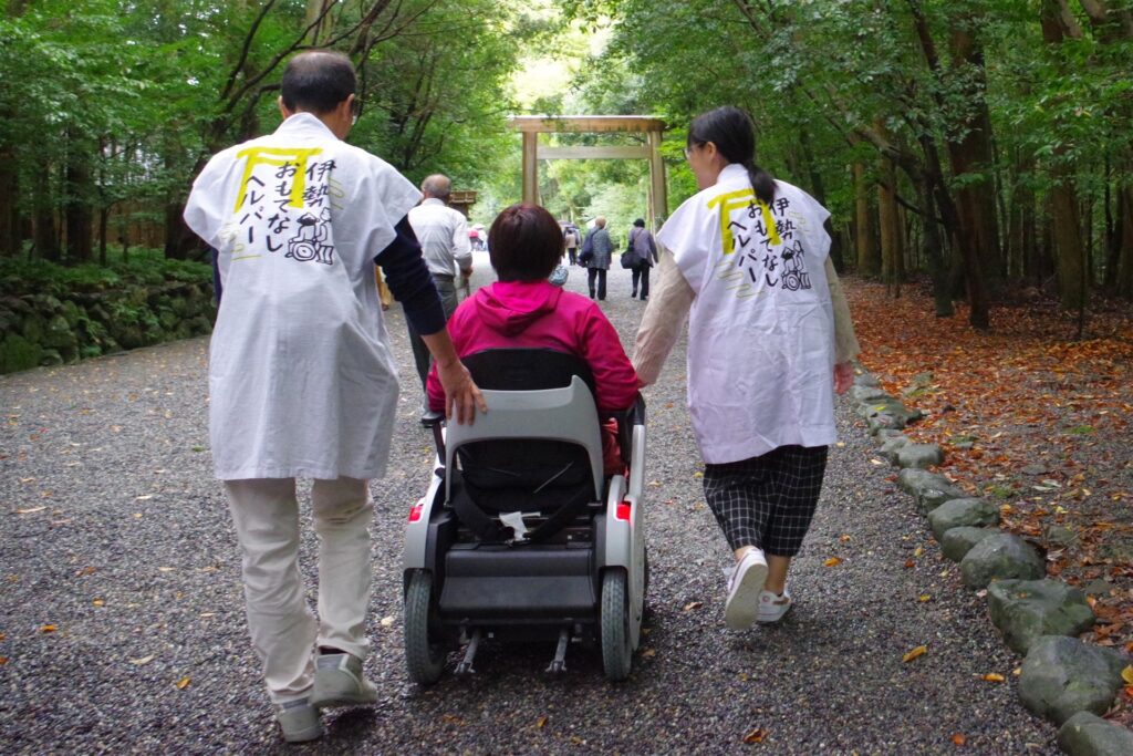 伊勢おもてなしヘルパーのスタッフと一緒に参拝する車いす利用者