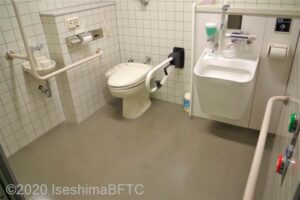 入口からみて左奥に、たて置きに便器。便器に腰掛けて前方に手洗い器。入口正面にオストメイト