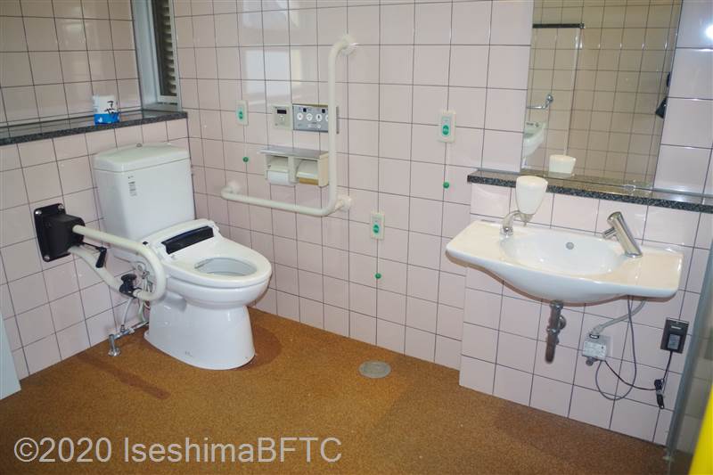 鳥羽中央公園車いす対応トイレ　入口からみて右奥に、たて置きに便器。入口からみて右手前に洗面台