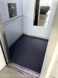 エレベーターの内部のようす。鏡や手すりなどが付いている。