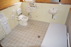 面白展望台　車いす対応トイレ大　内部　便器に向かって右側にＬ型固定手すり、左側にＵ型可動手すり