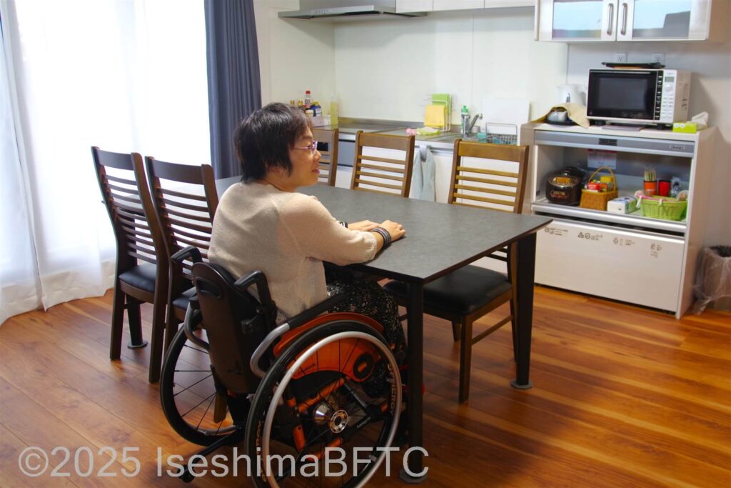 バリアフリー民泊でテーブルに向かう車いす利用者