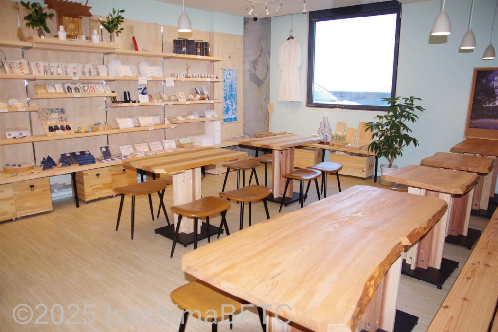 約6つのテーブルやお土産、雑貨が陳列された店内喫茶スペース