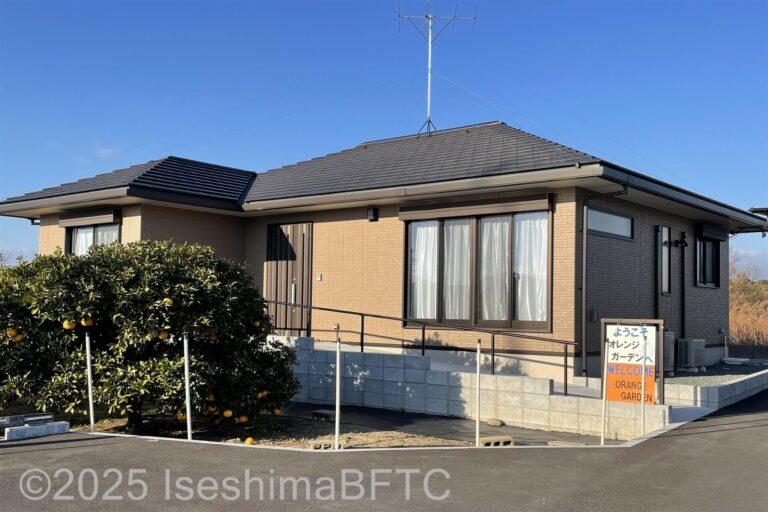 建物外観。スロープがあり、建物前には果物が実った樹木がある
