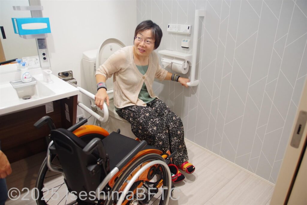 トイレに座る車いす利用者