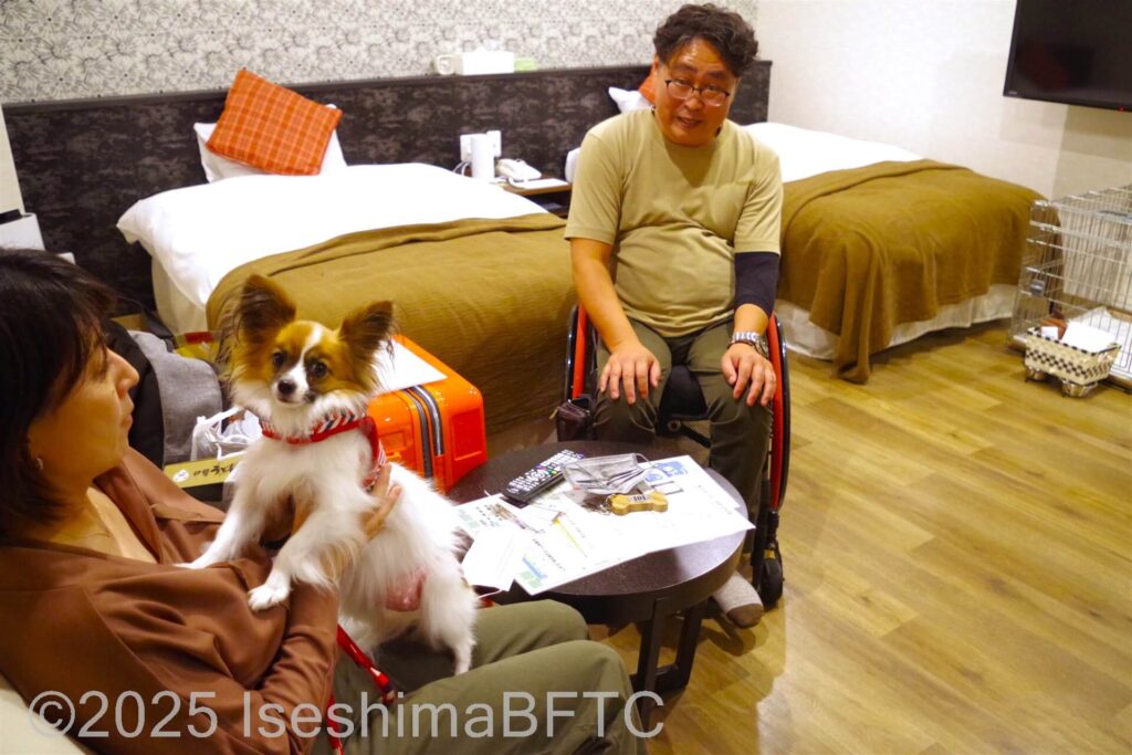 室内で愛犬とくつろぐ車椅子利用者と同行者