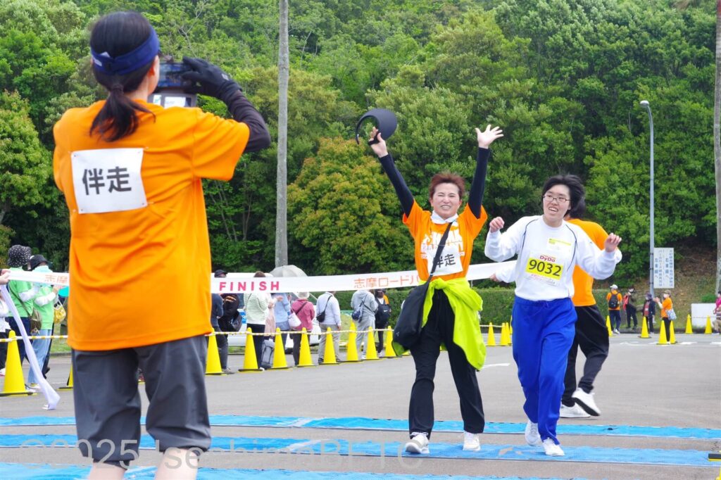 伴走ボランティアと一緒にゴールした選手と、それを写真に撮るボランティア