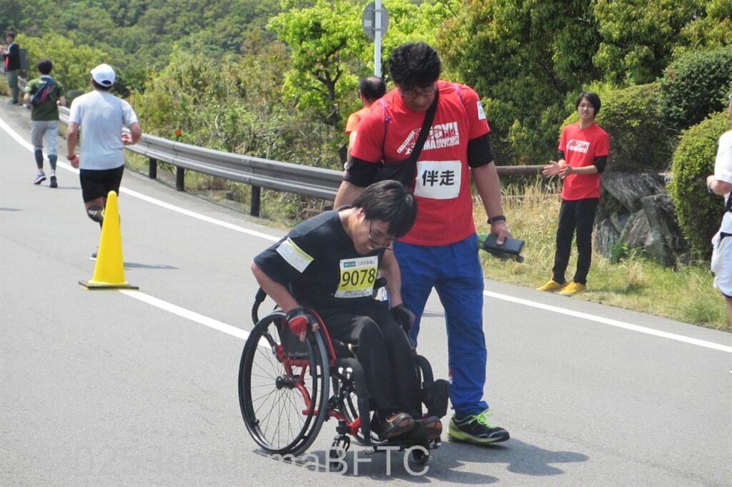 ボランティアと一緒に走る車いす選手