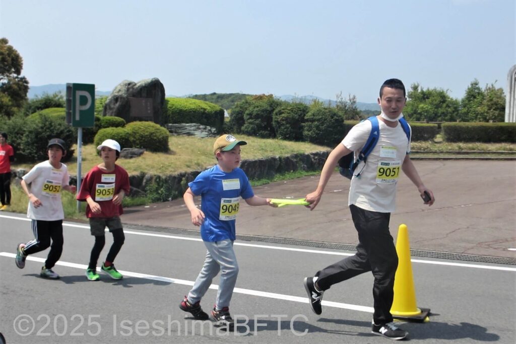 視覚障害があるため伴走のお父さんとの間をタオルでつないで走る選手
