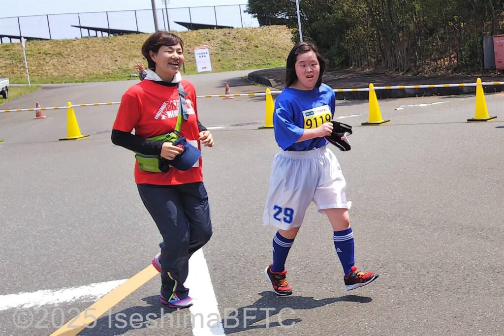 伴走ボランティアと一緒に走る知的障害の選手