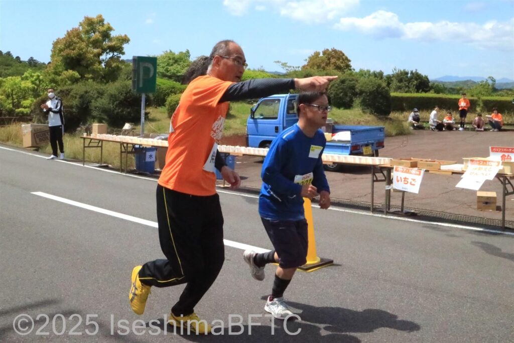 走りながらコースを教えるボランティアスタッフ
