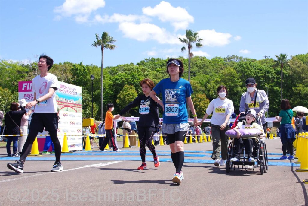 10キロのランナーと同時にゴールした介助式車いすの選手と家族