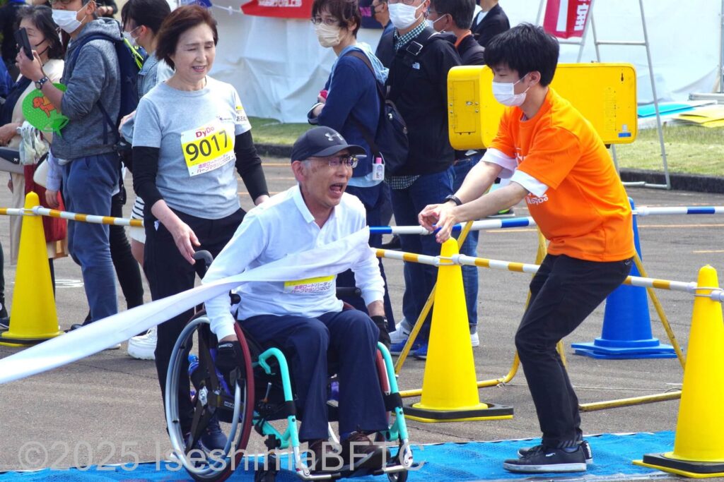 ゴールテープを切る自走式車いすの選手