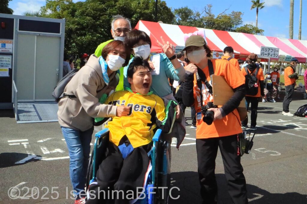 毎年参加の車いす選手とその家族、ボランティアで記念撮影