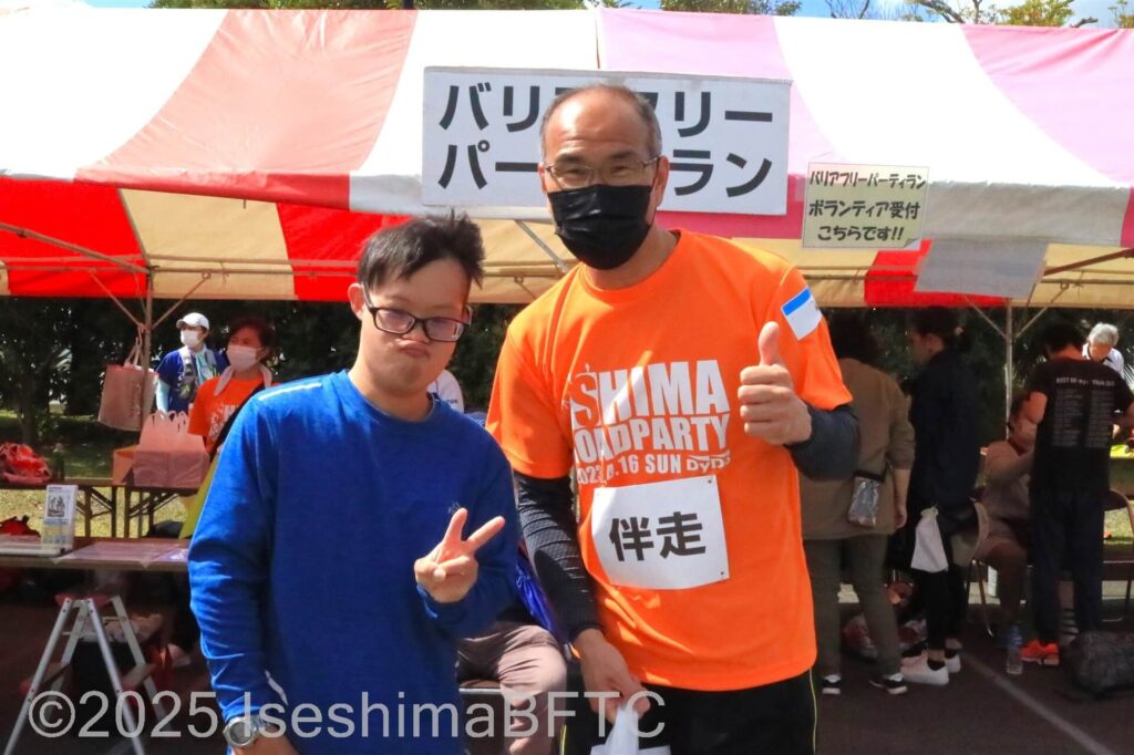 伴走ボランティアと一緒にピースサインの選手