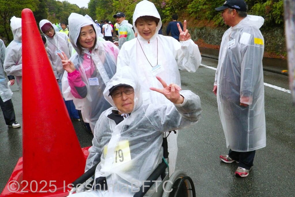 ピースしながら短縮コースを折り返す車いす使用者