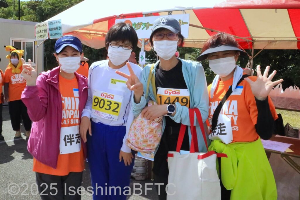一緒に走る選手と一緒に記念撮影をするボランティア