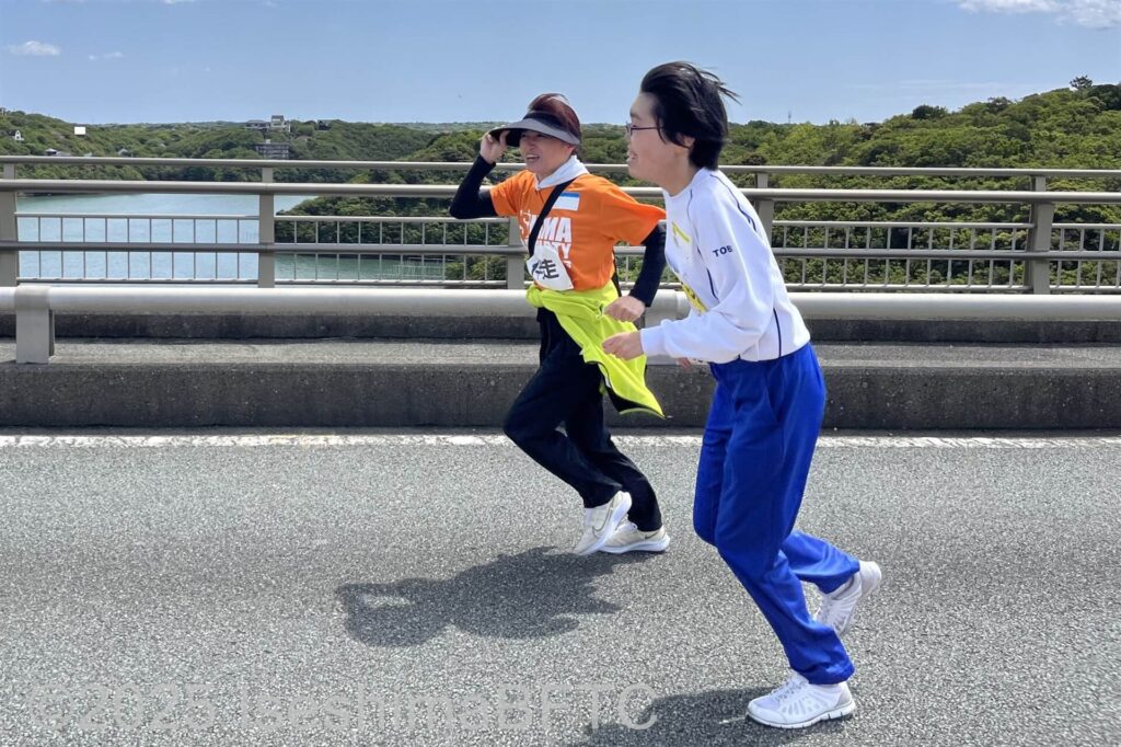 全速力で走る選手と、併走する伴走ボランティア