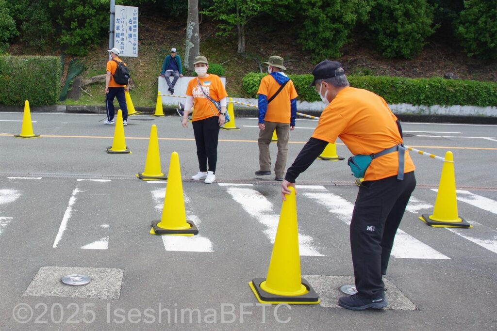 道路上のコーンを移動するボランティア