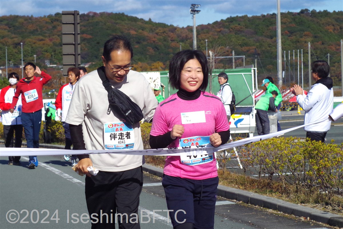 伴走者と一緒にゴールテープを切る選手