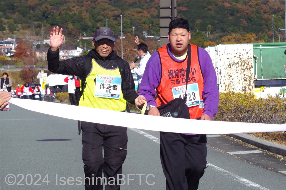 伴走者と一緒にゴールテープを切る視覚障害の選手
