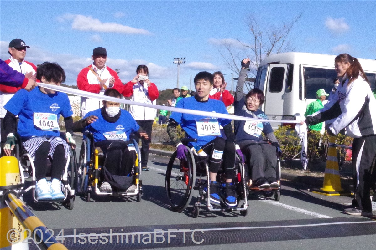 揃ってゴールテープを切る4名の車いす選手