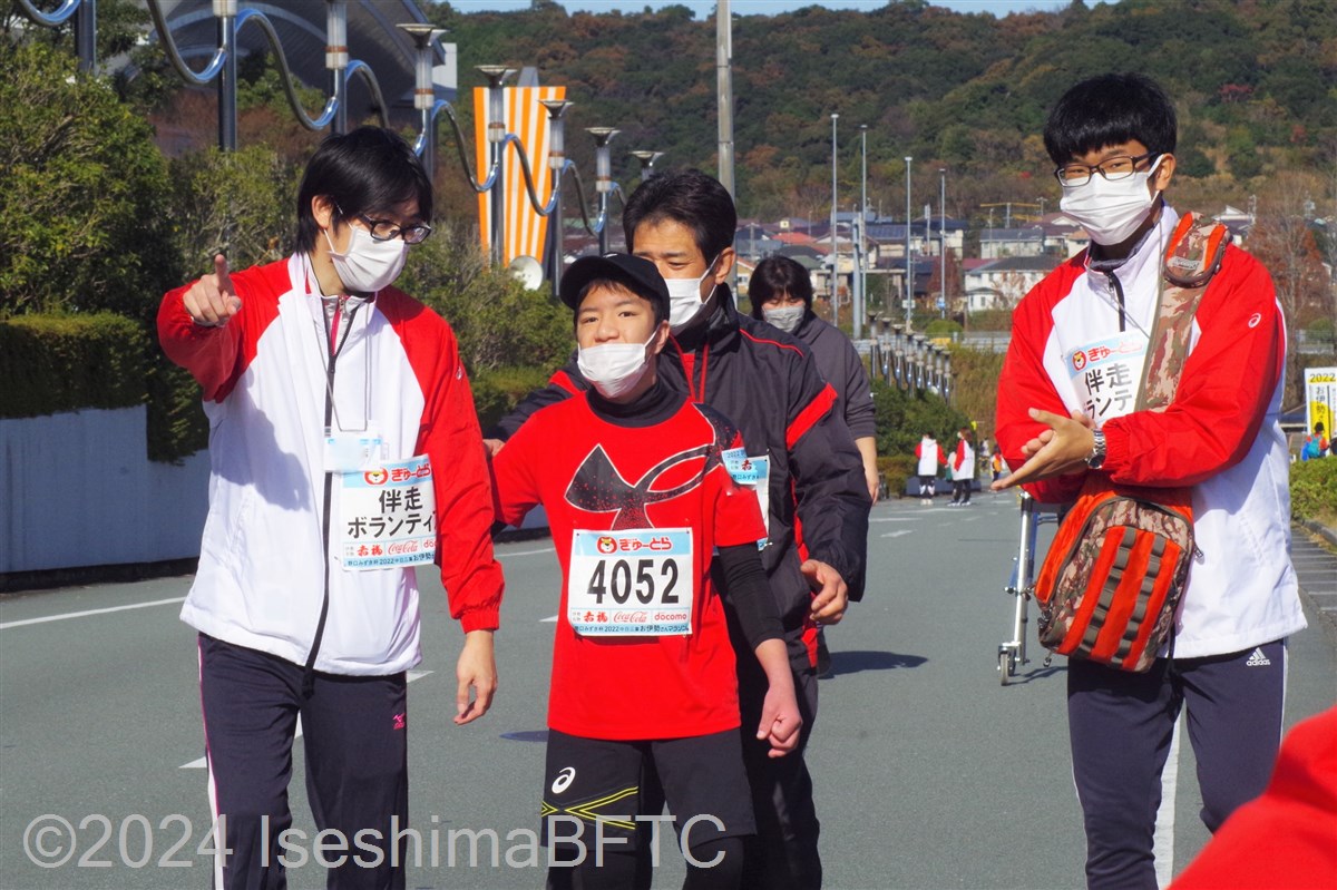 選手にゴールを指差す伴走ボランティアと、手拍子で励ます伴走ボランティア