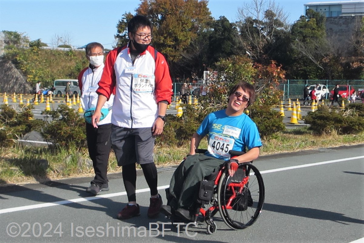 手動車いすの選手を横で見守る伴走ボランティア