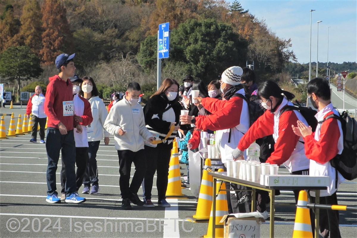 給水所で選手に水を渡すボランティア