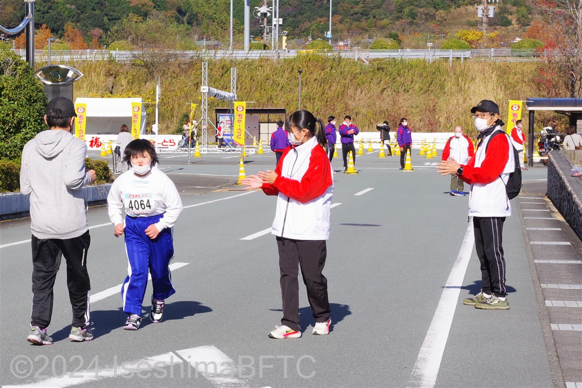 沿道から拍手で応援するボランティア