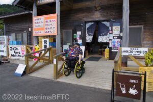 建物入口のスロープを自走で上がる車いすの男性のようす。