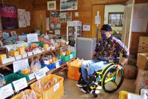 物販コーナーにいる車いすの男性のようす。