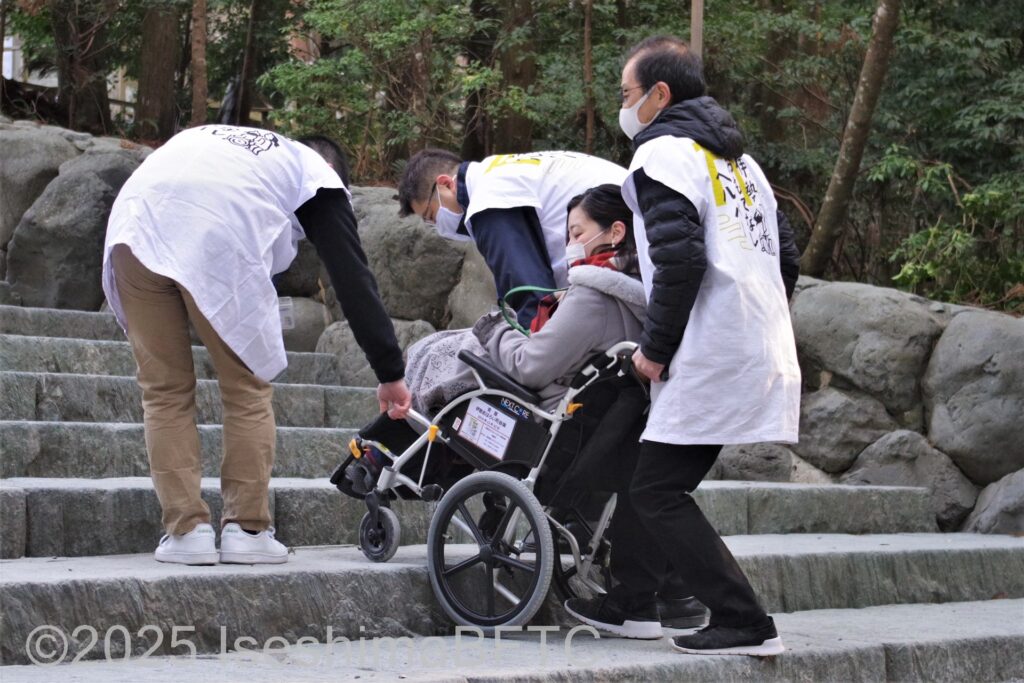 伊勢おもてなしヘルパーの人たちによるで内宮正殿の階段を車いすで上がる様子