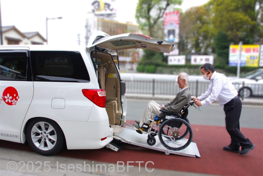 福祉タクシーへ乗車する車いすの男性とサポートする男性