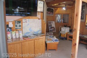 観光インフォメーションコーナー。壁には周辺の地図がかかっていて、棚にはたくさんの種類のパンフレットが置かれている。映像での観光紹介もある。