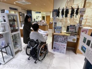 観光案内所で車いすの女性がスタッフの説明を受けているようす。