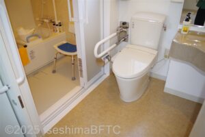 便器と浴室の入り口のようす　左手のU字手すりにはトイレットペーパーホルダー付き　