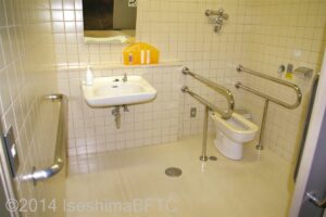 車いす対応トイレの個室内のようす。
便器の両側にU字手すりが設置されている。