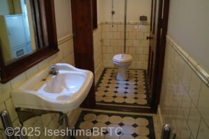 実際に使われていたトイレのようす。水洗式の洋式トイレとなっていて、当時のままの白黒模様のタイルが美しい。
