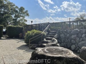 旧宅の向かい側にある石垣のようす。階段を上がると、旧宅の2階にある「ずずのや」が覗けるようになっている。