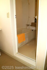 浴室の入り口　ドアは開き戸うち開き　左手に浴槽　左奥にシャワー
