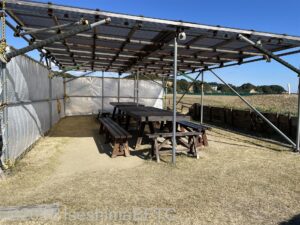 東屋のようす。屋外にあり、屋根の下にイスとテーブルが置かれている。