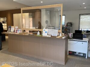 受付カウンターのようす。カウンターには筆談対応可能のピクトグラムが掲げられている。