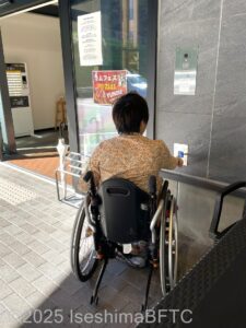 インターフォンを押そうとしている車いすの女性