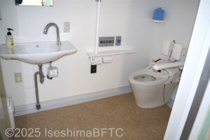 トイレ便房内　入り口入って正面洗面　右手奥に便器　左壁面にL字手すり　右I字の跳ね上げ手すり