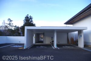 建物の裏手に設けられた駐車スペースのようすのようす。2台分は白いコンクリートの屋根がかかっている。