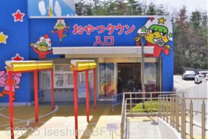 おやつタウン建物入口のようす。入口の上にはベビースターラーメンのキャラクターのホシオくんが描かれている。