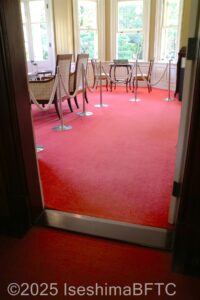 洋館の部屋の入口のドア下には段差がある。床には赤いカーペットが敷かれている。